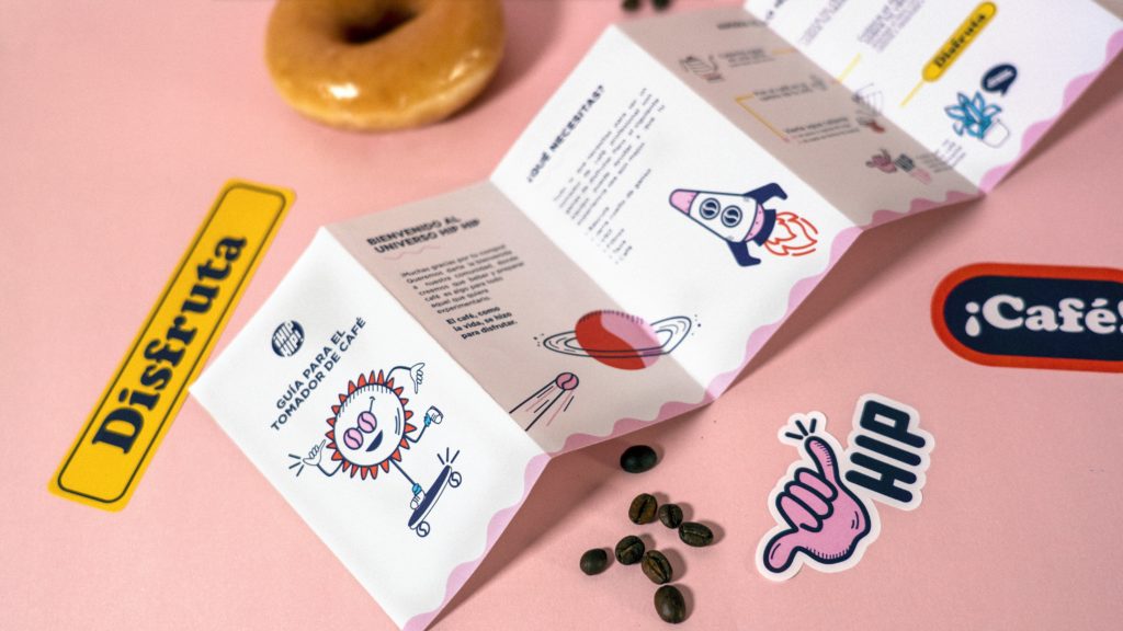 A roll fold leaflet on a pink background with various stickers around it