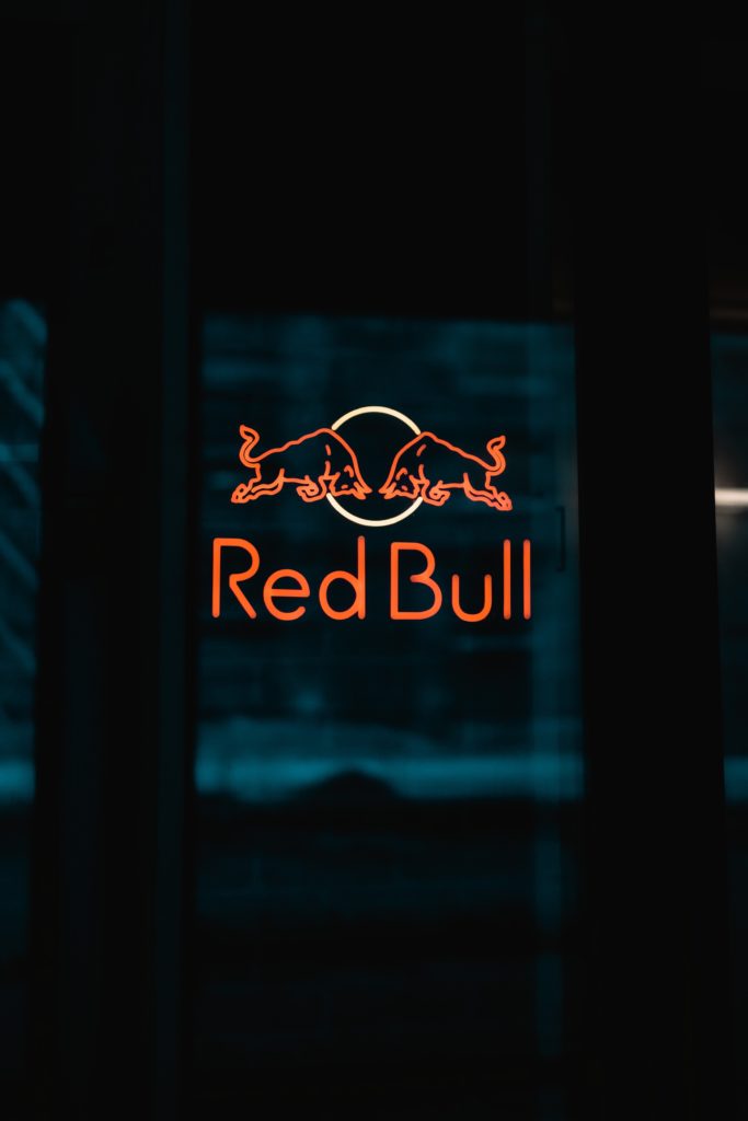 A neon sign of the Red Bull logo