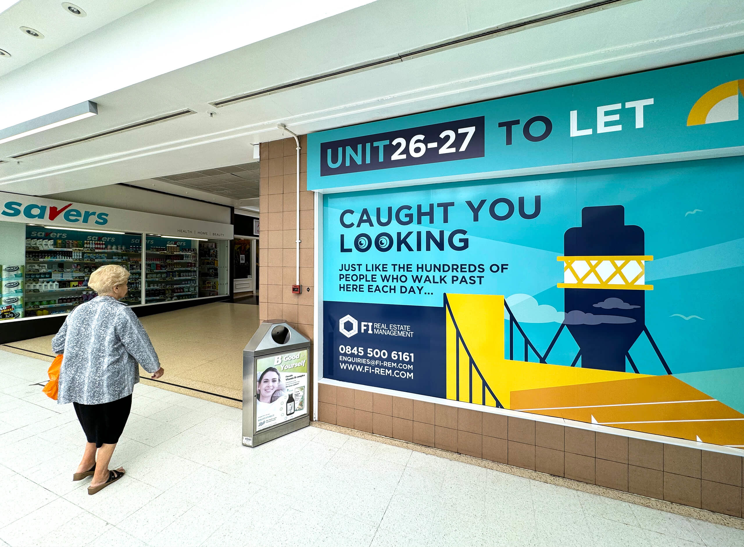 North Point Shopping Centre window graphics showcasing a unit for rent. A female passer-by takes a look at the graphic.
