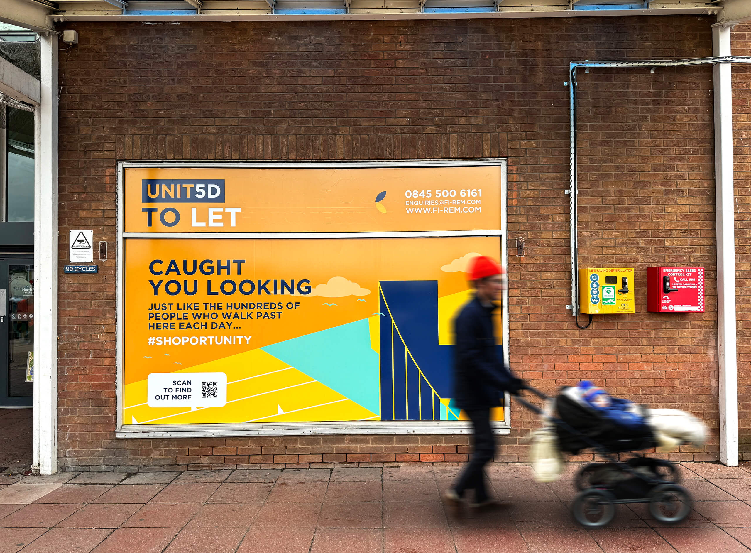 North Point Shopping Centre external window graphics showcasing a unit for rent. A passer-by with a baby walks past the shot in blur.